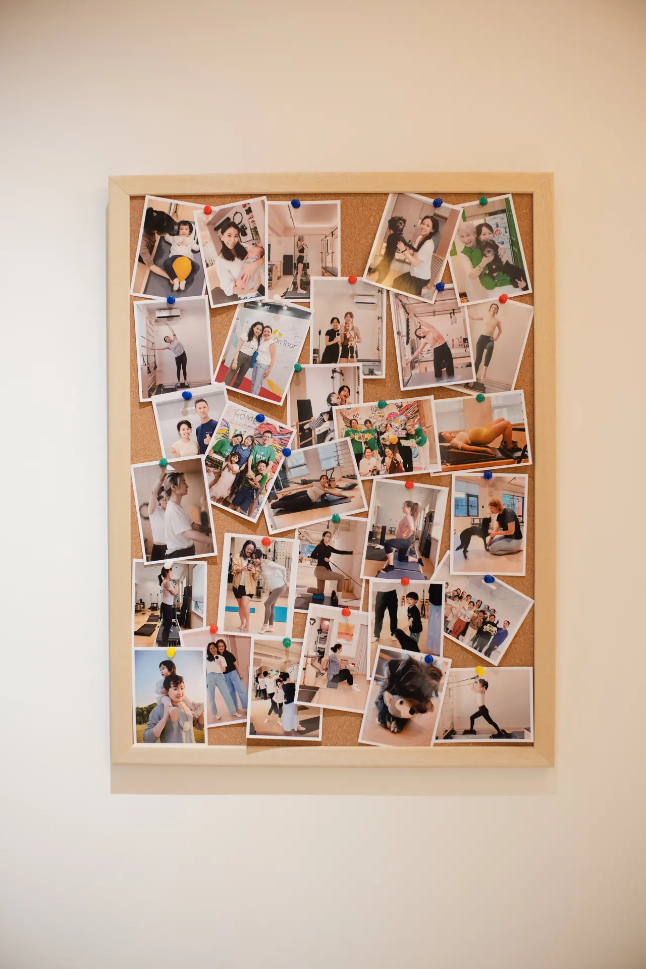 A cork wall filled with photographs from the studio community